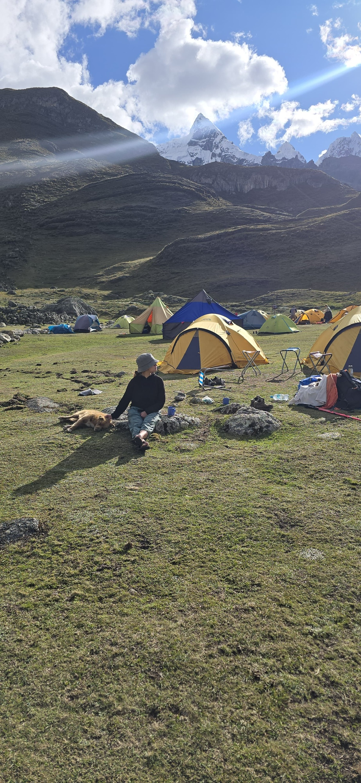 Sim resting beside a stray dog at camp during a hike in Peru’s Huayhuash mountains